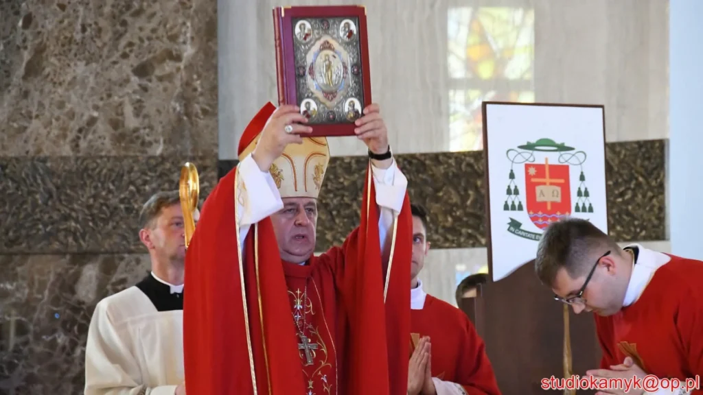 Biskup ukazuje księgę Ewangelii podczas uroczystości poświęcenia kościoła