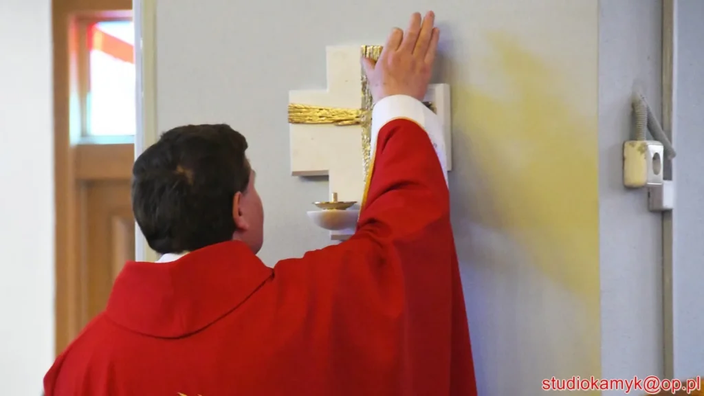 Namaszczenie krzyża na ścianie kościoła podczas uroczystości poświęcenia